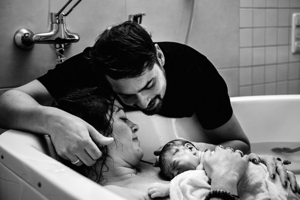 Emotionale Geburtsfotos: Familie umarmt Neugeborenes im Klinikum Dritter Orden in München, fotografiert von Kasia Warpas.